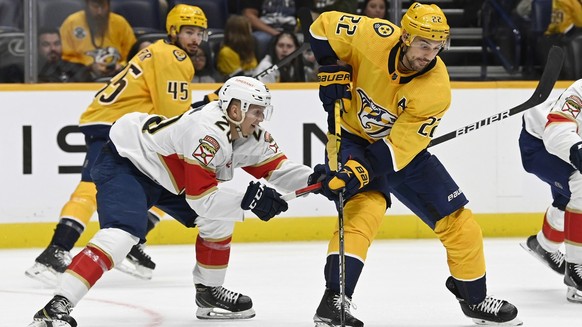 Nashville Predators right wing Nino Niederreiter (22) maneuvers the puck ahead of Florida Panthers forward Aleksi Heponiemi (20) during the third period of an NHL preseason hockey game Monday, Sept. 2 ...