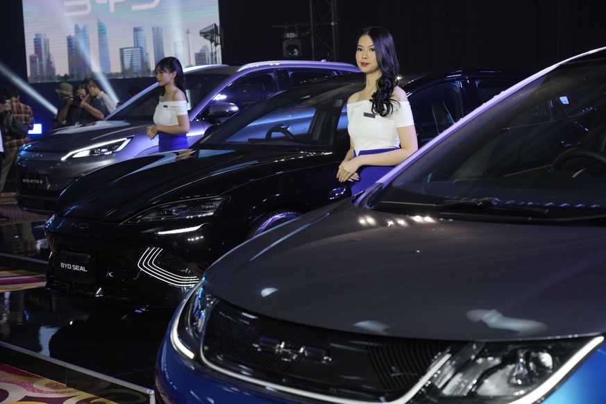 FILE - Models stand near BYD electric cars on display, from left, Atto 3, Seal and Dolphin, during a launch event in Jakarta, Indonesia, on Jan. 18, 2024. (AP Photo/Achmad Ibrahim, File)