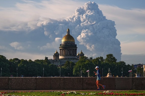 Smoke billows into the sky following Ukrainian drone strikes on warehouses of Russia's online retailer Wildberries, in St. Petersburg, Russia, Friday, July 24, 2026, backdropped by the St. Isaac& ...