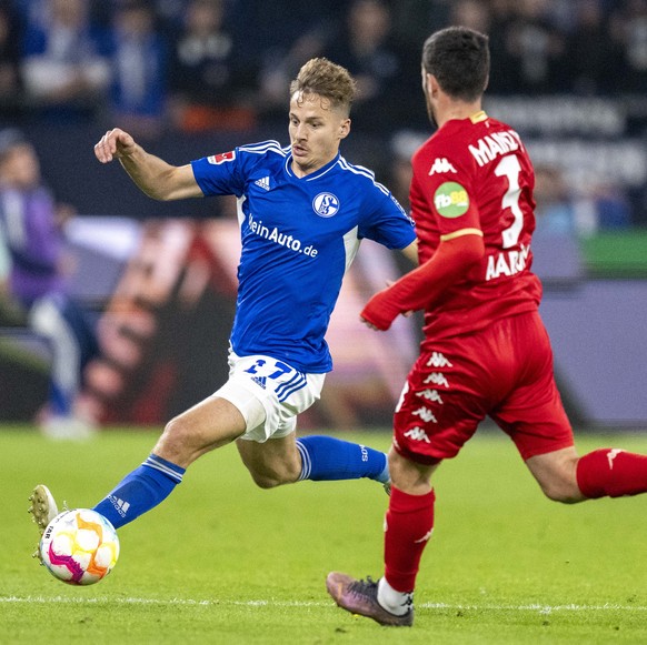 09.11.2022, Nordrhein-Westfalen, Gelsenkirchen: Fu�ball: Bundesliga, FC Schalke 04 - 1. FSV Mainz 05, 14. Spieltag, Veltins Arena: Schalkes Cedric Brunner (l) und Aaron Martin von Mainz k�mpfen um den ...