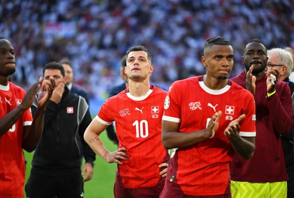 06.07.2024, Nordrhein-Westfalen, Düsseldorf: Fußball, UEFA Euro 2024, EM, England - Schweiz, Finalrunde, Viertelfinale, Düsseldorf Arena, Granit Xhaka (M) von der Schweiz und seine Teamkollegen reagie ...