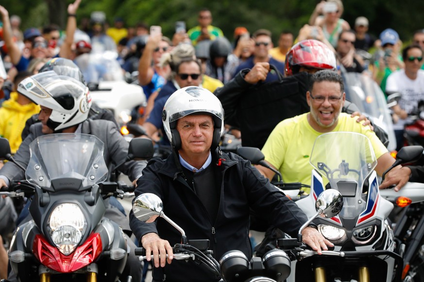 epa10008900 A handout photo made available by the Planalto Palace, seat of the executive power of the Brazilian Federal Government, shows the president of Brazil, Jair Bolsonaro (C), leading a motorcy ...