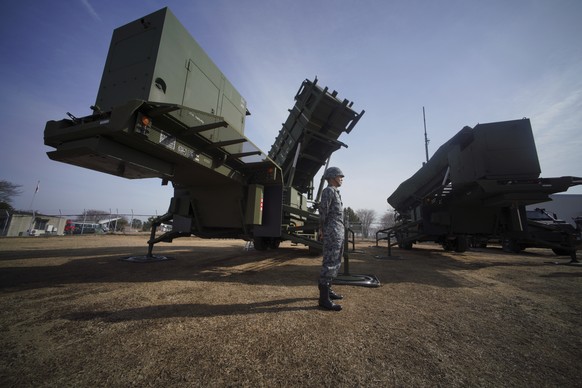 FILE - A member of the Japan Ground Self-Defense Force stands guard next to a surface-to-air Patriot Advanced Capability-3 (PAC-3) missile interceptor launcher vehicle in Funabashi, east of Tokyo, on  ...