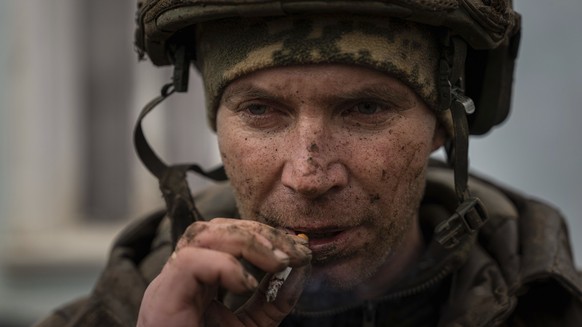 A Ukrainian serviceman who recently returned from the trenches of Bakhmut smokes a cigarette in Chasiv Yar, Ukraine, Wednesday, March 8, 2023. (AP Photo/Evgeniy Maloletka)