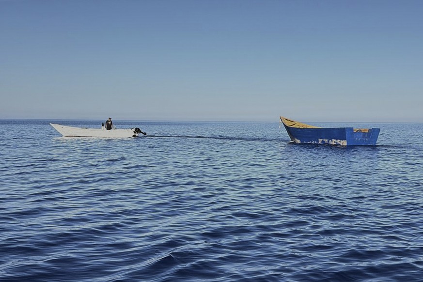 A boat used by migrants to cross the Mediterranean Sea is towed from Tripiti beach to the Karave the port of Gavdos, Greece, on Monday, July 7, 2025 after hundreds were rescued near the island and the ...