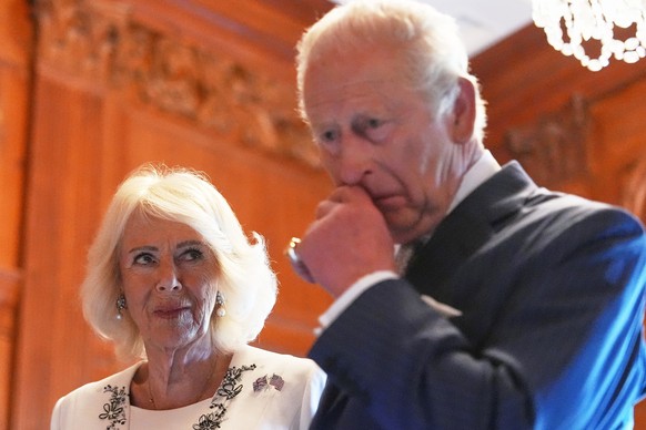 Queen Camilla and King Charles III look over items to be placed in a time capsule in honor of the United States' 250th anniversary in the Ambassador's Library room of the British Embassy, Mo ...
