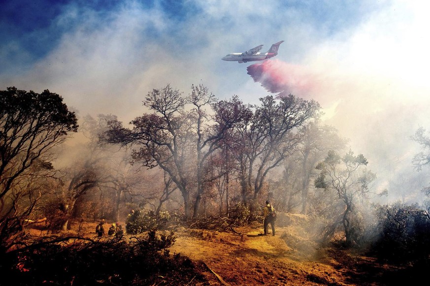 An air tanker drops retardant on the Olinda Fire burning in Anderson, Calif., Sunday, Oct. 25, 2020. The blaze was one of four fires burning near Redding that firefighters scrambled to stop as high wi ...