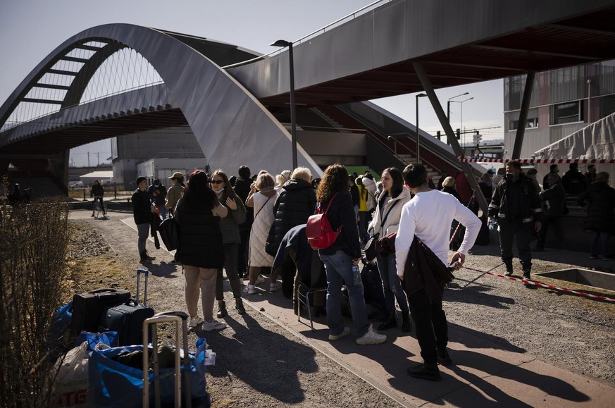 Des réfugiés ukrainiens font la queue et attendent d'être enregistrés devant le centre fédéral d'asile de Zürich, le dimanche 13 mars 2022 à Zürich.