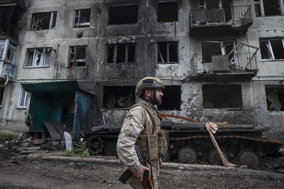 FILE - A Ukrainian soldier passes by a damaged apartment building in Chasiv Yar, the site of heavy battles with the Russian forces in the Donetsk region, Ukraine, Tuesday, May 9, 2023. (Iryna Rybakova ...