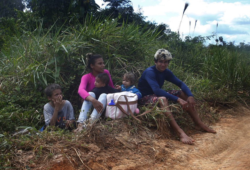 Une famille quitte le territoire yanomami. La population souffre de malnutrition et de la malaria à cause des conséquences environnementales de l'orpaillage.