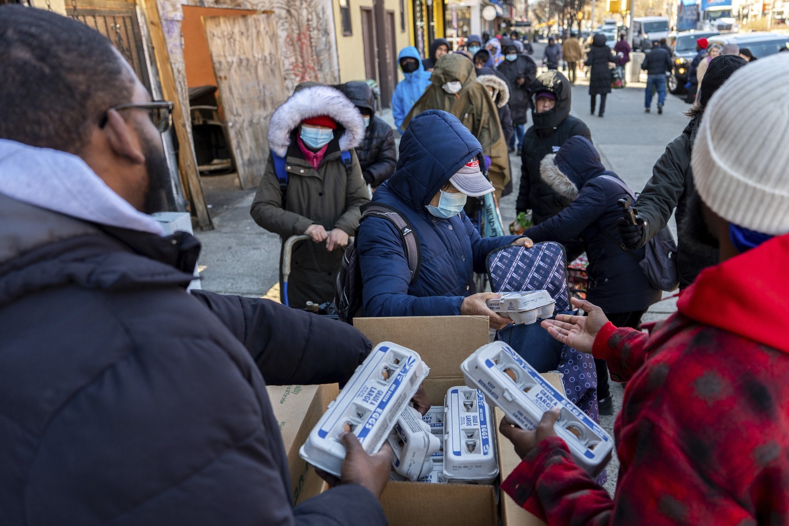 Abou Sow hands out cartons of eggs to people waiting in line to receive free eggs from FarmerJawn Agriculture, Friday, March 21, 2025, in the Harlem neighborhood of New York. (AP Photo/Julia Demaree N ...