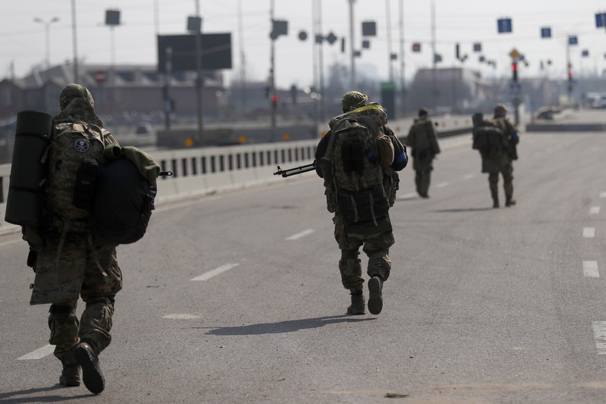 epa09844619 Ukrainian soldiers patrol on the outskirt of Kiev (Kyiv), Ukraine, 23 March 2022. Russian troops entered Ukraine on 24 February prompting the country's president to declare martial la ...