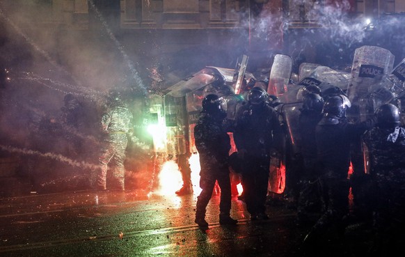 epa11755467 Georgian opposition supporters launch fireworks towards the police during a protest in front of the Parliament building in Tbilisi, Georgia, 03 December 2024. Thousands of pro-EU activists ...