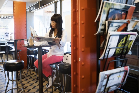 Sharon liest Zeitung in der Cafe Bar Adrianos, am Montag 31. Mai 2021 in Bern. Ab heute duerfen die Restaurants auch die Tische im Innern wieder besetzen. (KEYSTONE/Peter Klaunzer)