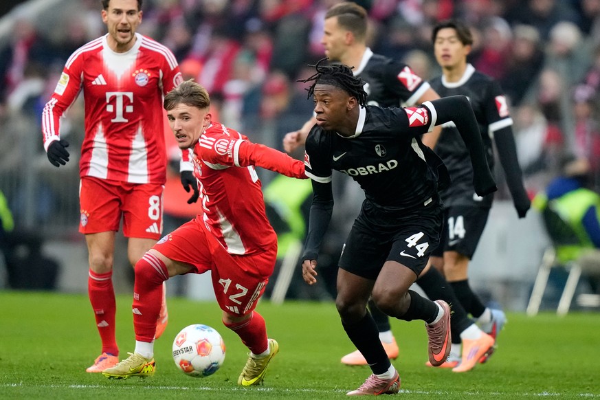 Bayern&#039;s Lennart Karl, left, and Freiburg&#039;s Johan Manzambi challenge for the ball during the Bundesliga soccer match between Bayern Munich and Freiburg in Munich, Germany, Saturday, Nov. 22, ...