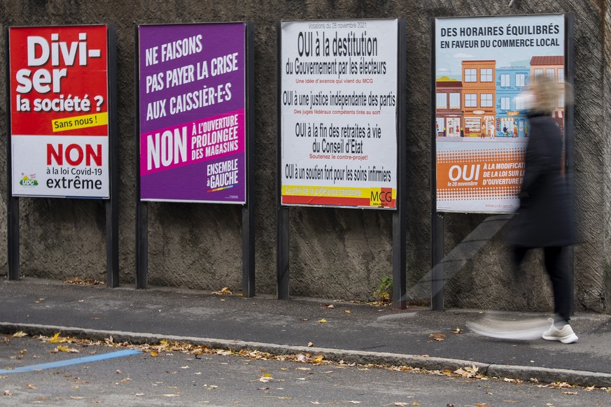 Une personne passe devant les affiches des partis politiques et des associations donnant leurs mots d&#039;ordre pour les votations federales et cantonales du 28 novembre, ce samedi 27 novembre 2021 a ...