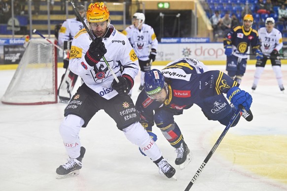 Gotterons Christopher DiDomenico, links, gegen Davos&#039; Matej Stransky, beim Eishockey Spiel der National League zwischen dem HC Davos und dem HC Fribourg-Gotteron, am Montag, 14. Maerz 2022, im Ei ...