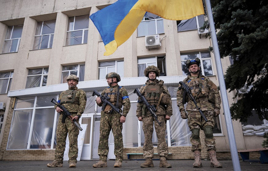 epa10223138 Ukrainian servicemen attend the ceremony of raising the National flag in the recently recaptured city of Lyman, Donetsk area, Ukraine, 04 October 2022. The Ukrainian army pushed Russian tr ...