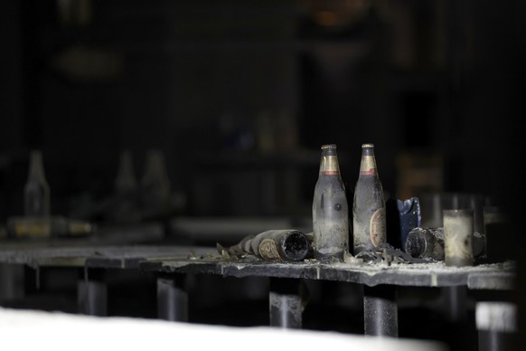 epa13107714 Damaged beer bottles stand inside a pub after a fire in Bangkok, Thailand, 13 July 2026. At least 27 people were killed after a fire engulfed the pub, according to Thai Prime Minister Anut ...