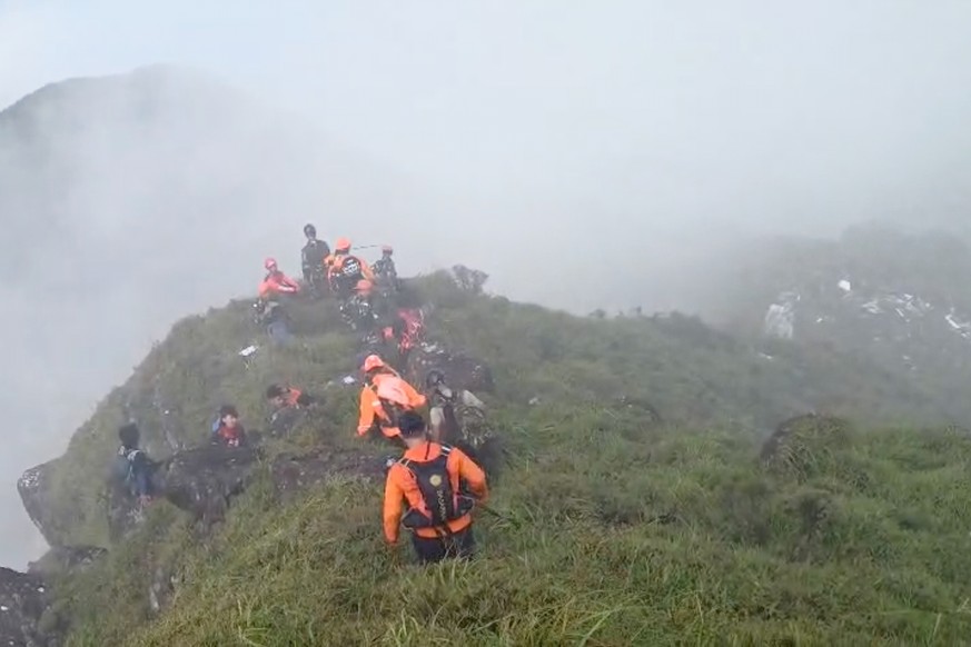 In this photo provided by the Indonesian National Search and Rescue Agency (BASARNAS), members of its rescue team conduct a searching operation around Mount Bulusaraung, South Sulawesi province, Indon ...