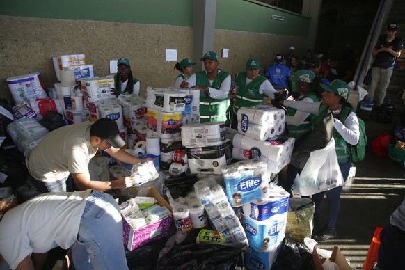 epa13162463 People sort supplies at a collection center in Cali, Colombia, 11 August 2026. Colombia is focusing its efforts on searching for survivors, providing assistance to those affected, and asse ...