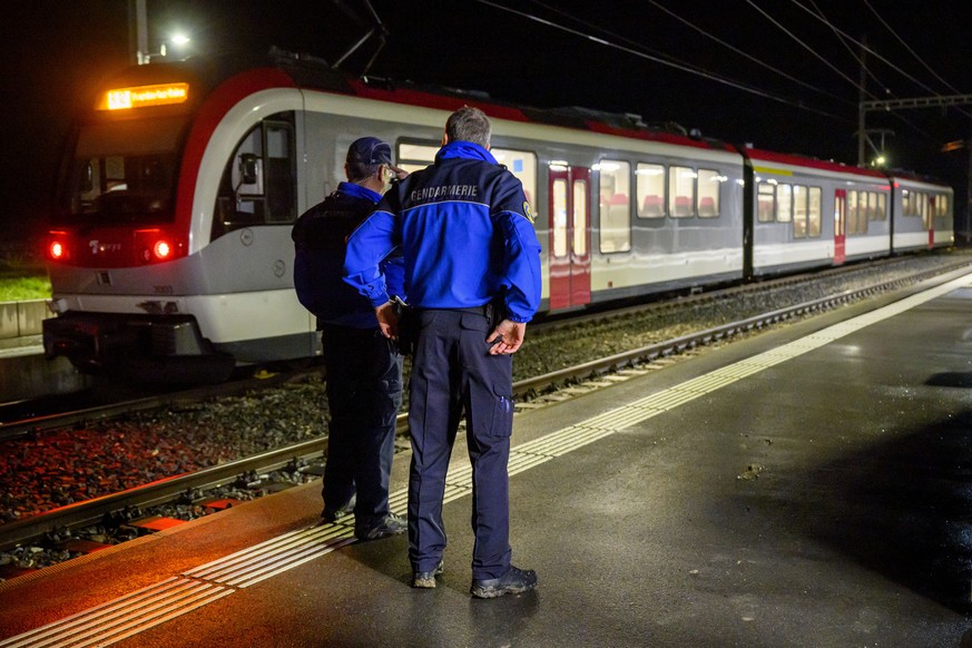 Vaud cantonal police officers watch the Travys train where a hostage-taking incident took place at Essert-sous-Champvent station, Switzerland, Thursday, 8, February, 2024. A hostage-taking incident to ...