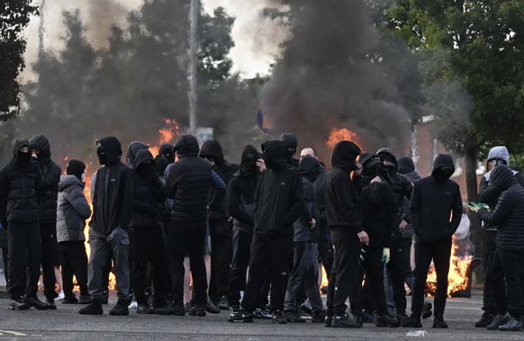 Des individus masqués participent à des émeutes à Belfast.