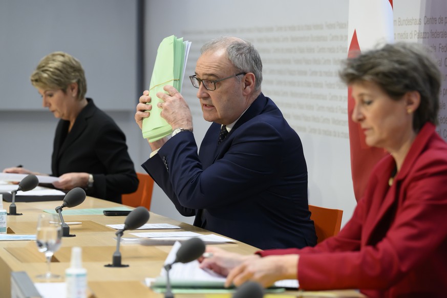 Bundesrat Guy Parmelin, Mitte, spricht an der Seite von Bundesraetin Karin Keller-Sutter, links, und Bundesraetin Simonetta Sommaruga, rechts, an einer Medienkonferenz ueber die Ukraine Krise, am Frei ...