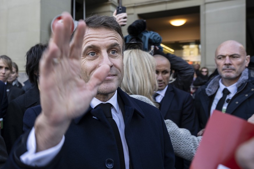 epa10976375 French President Emmanuel Macron greets people in front of the Federal Palace, the Swiss Parliament building, in Bern, Switzerland, 15 November 2023. French President Macron and his wife B ...