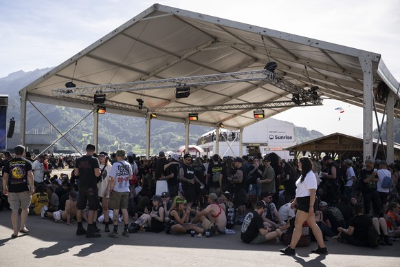 Festival-goers take shelter in the shade of a tent during the final day of the Greenfield Openair Festival in Interlaken, Switzerland, Saturday, June 13, 2026. (KEYSTONE/Anthony Anex)