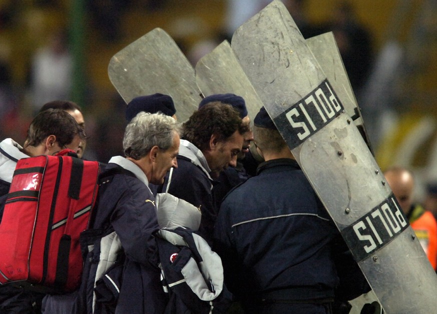 Switzerland&#039;s assistant coach Michel Pont, center, leaves the pitch protected by police shields after the FIFA 2006 qualifying play-off second leg soccer match between Turkey and Switzerland at S ...