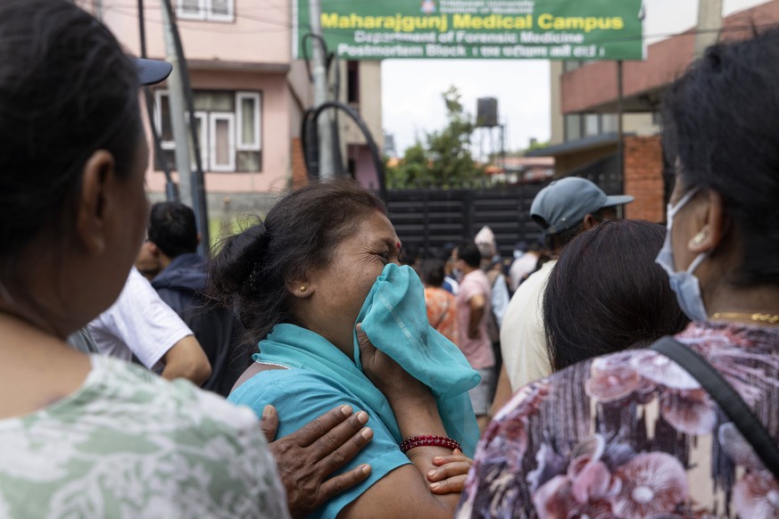 epa13198126 Relatives of victims and missing people following flash floods react as they gather outside the morgue of the Tribhuvan University Teaching Hospital (TUTH), in Kathmandu, Nepal, 29 August  ...