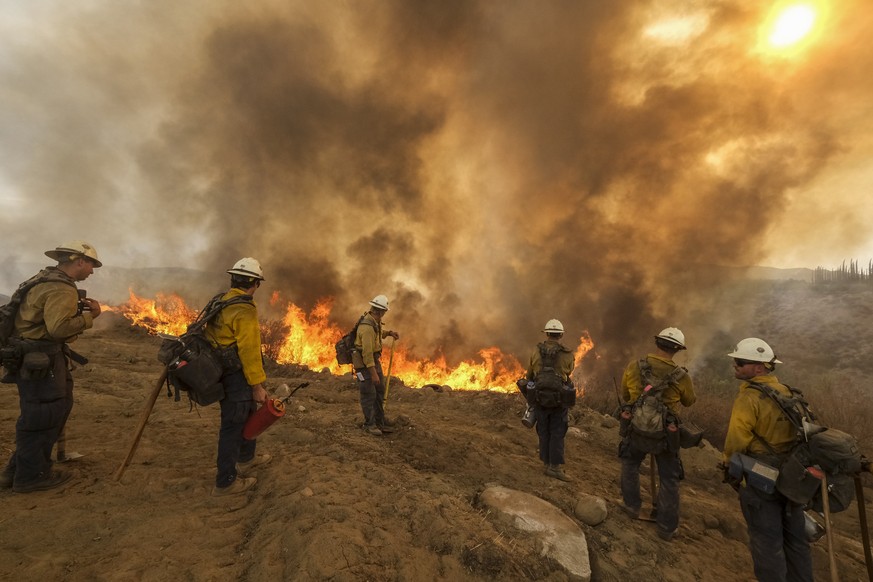 Firefighters watch as the Fairview Fire burns on a hillside Thursday, Sept. 8, 2022, near Hemet, Calif. (AP Photo/Ringo H.W. Chiu)