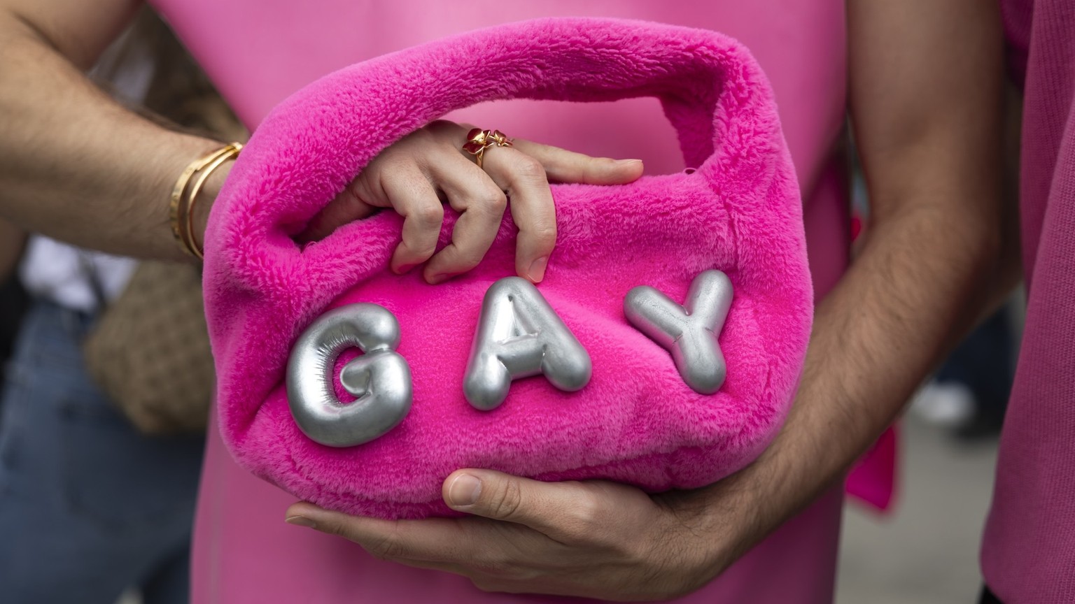 A gay person holds a handbag prior to the start of a pride parade in Bern, Switzerland, Saturday, August 2, 2025. (KEYSTONE/Peter Klaunzer)