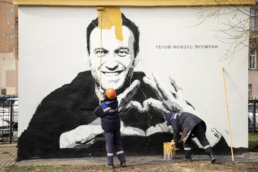 Des employés municipaux peignent les graffitis du chef de l&#039;opposition russe emprisonné Alexei Navalny à Saint-Pétersbourg, Russie, le mercredi 28 avril 2021. Sur le mur, on peut lire &quot;Héros ...