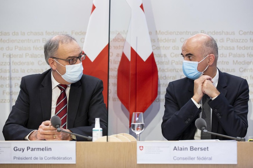 Bundesrat Alain Berset, rechts, diskutiert mit Bundespraesident Guy Parmelin, waehrend einer Medienkonferenz des Bundesrates zur aktuellen Lage im Zusammenhang mit dem Coronavirus, am Mittwoch, 13. Ja ...