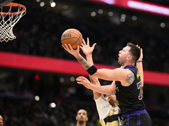 Kyshawn George en train d'essayer de défendre sur Luka Doncic