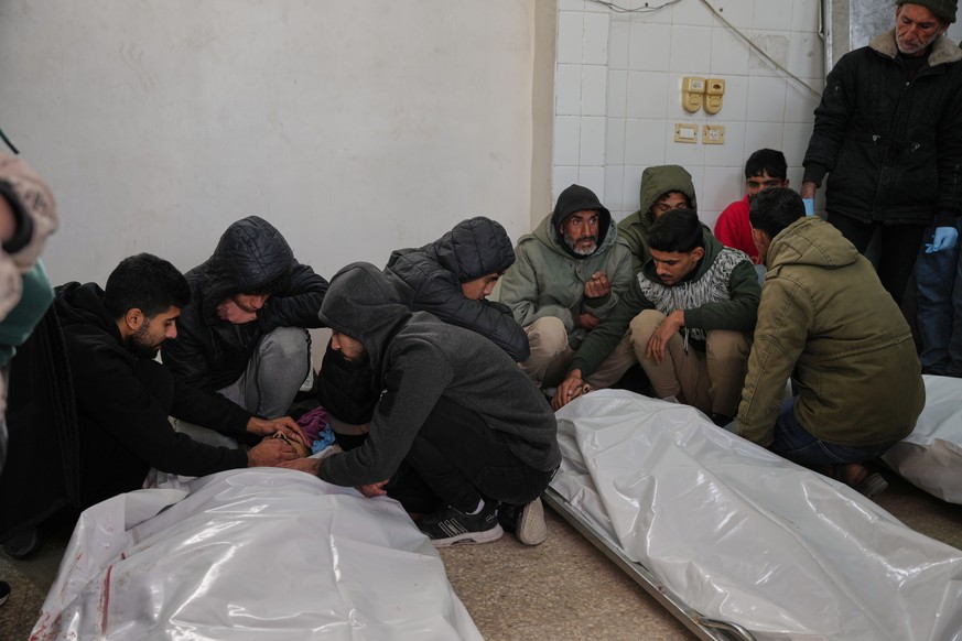 Palestinians mourn over the bodies of people who were killed in an Israeli strike, before their funeral at Al-Aqsa Hospital in Deir al-Balah, central Gaza Strip, Friday, Jan. 30, 2026. (AP Photo/Abdel ...