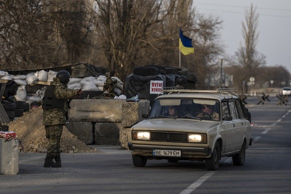 An Ukranian soldier allows a car to cross a check point in the outskirts of Mykolaiv, Ukraine, Saturday, March 26, 2022.(AP Photo/Petros Giannakouris)