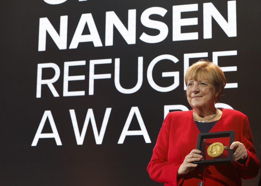 epa10235136 Former Chancellor of Germany Angela Merkel poses with the United Nations High Commissioner for Refugees (UNHCR) Nansen Refugee Award for protecting refugees at the height of the Syria cris ...
