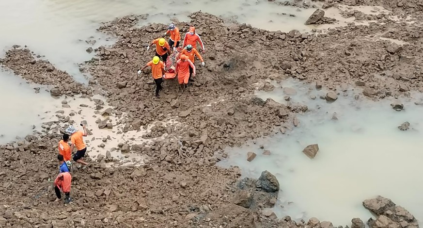 This photograph provided by India&#039;s National Disaster Response Force (NDRF) shows NDRF personnel carrying the body of a victim of a mudslide in Noney, northeastern Manipur state, India, Friday, J ...