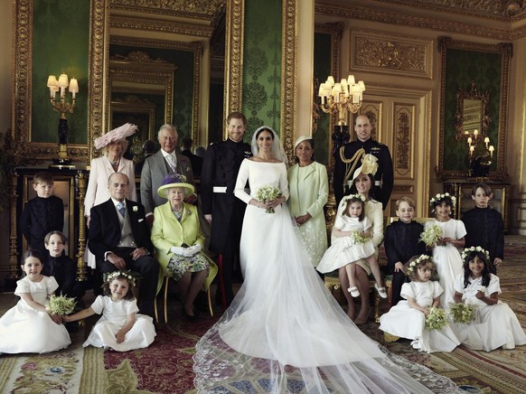 In this photo released by Kensington Palace on Monday May 21, 2018, shows an official wedding photo of Britain's Prince Harry and Meghan Markle, center, in Windsor Castle, Windsor, England, Saturday M ...
