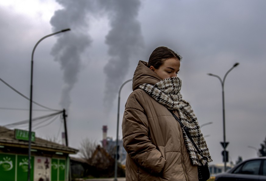 Une jeune Macédonienne porte un foulard sur son visage alors qu'elle passe devant une usine, à Skopje.