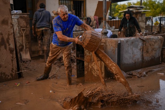 A man cleans his house affected by floods in Utiel, Spain, Wednesday, Oct. 30, 2024. (AP Photo/Manu Fernandez)