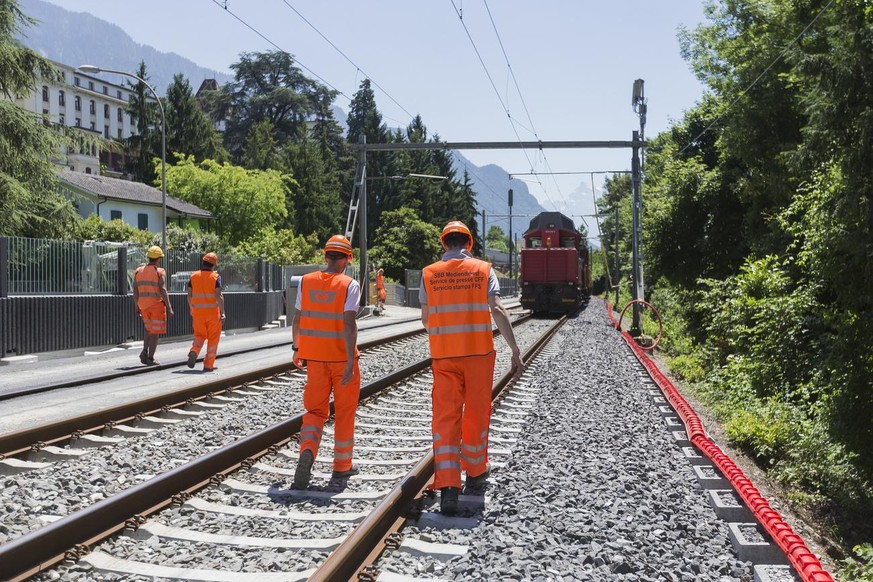 Des ouvriers marchent le long de la voie de chemin de fer entre Montreux et Villeneuve ce samedi, 17 juin 2017. Les CFF poursuivent l&#039;adaptation de la ligne du Simplon au gabarit des trains a deu ...