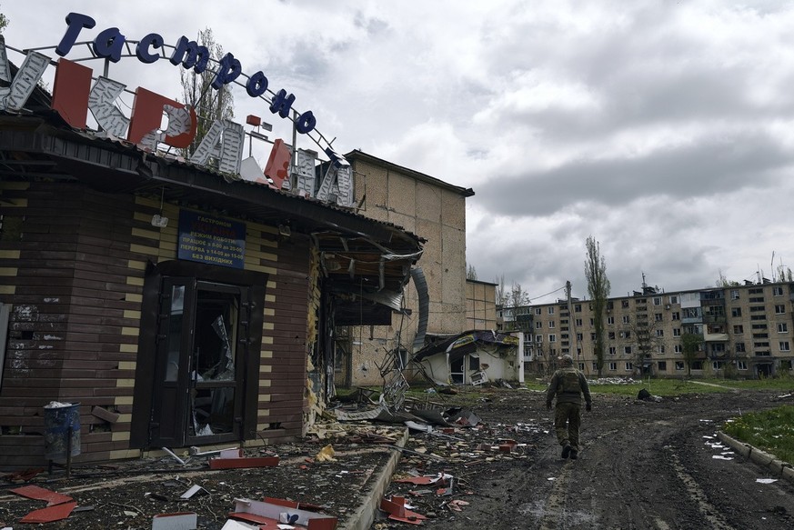A Ukrainian soldier walks in Avdiivka, the site of heavy battles with the Russians in the Donetsk region, Ukraine, Friday, April 28, 2023. (AP Photo/Libkos)