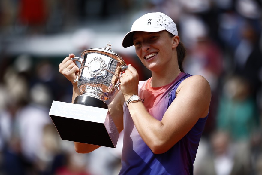 epa11397809 Iga Swiatek of Poland poses with the Suzanne-Lenglen-trophy after winning her Women's Singles final match against Jasmine Paolini of Italy during the French Open Grand Slam tennis tou ...