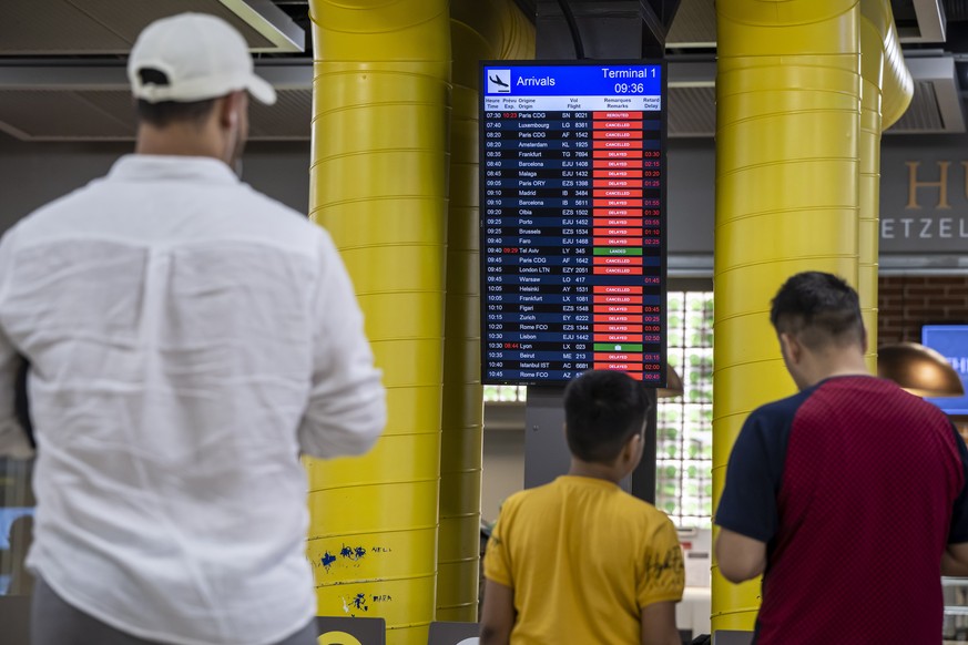 epa10013972 People check arrivals status after several flights were canceled, at Geneva Airport in Geneva, Switzerland, 15 June 2022. Flights resumed over Switzerland after the airspace had been close ...