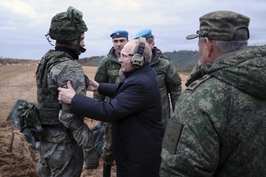 FILE - Russian President Vladimir Putin, center, speaks to a soldier while visiting a military training center of the Western Military District in the Ryazan region of Russia as Defense Minister Serge ...