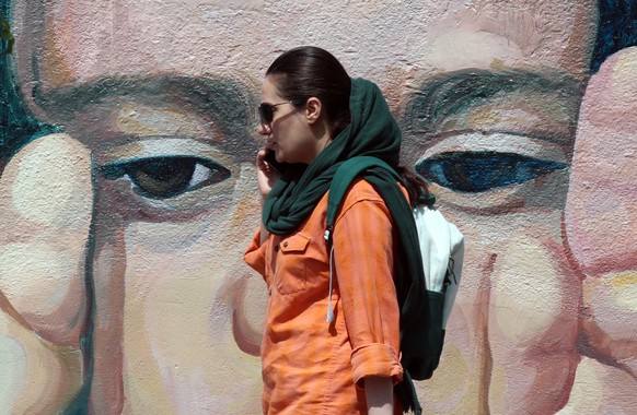 epa11300279 A woman walks past a wall painting of a child in Tehran, Iran, 25 April 2024. Tension between Iran and Israel continues since Iran&#039;s Islamic Revolutionary Guards Corps (IRGC) launched ...